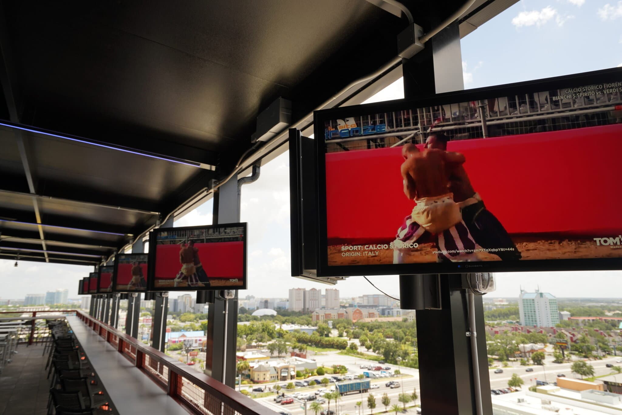 Rooftop bar with TVs showing Calcio Storico match.