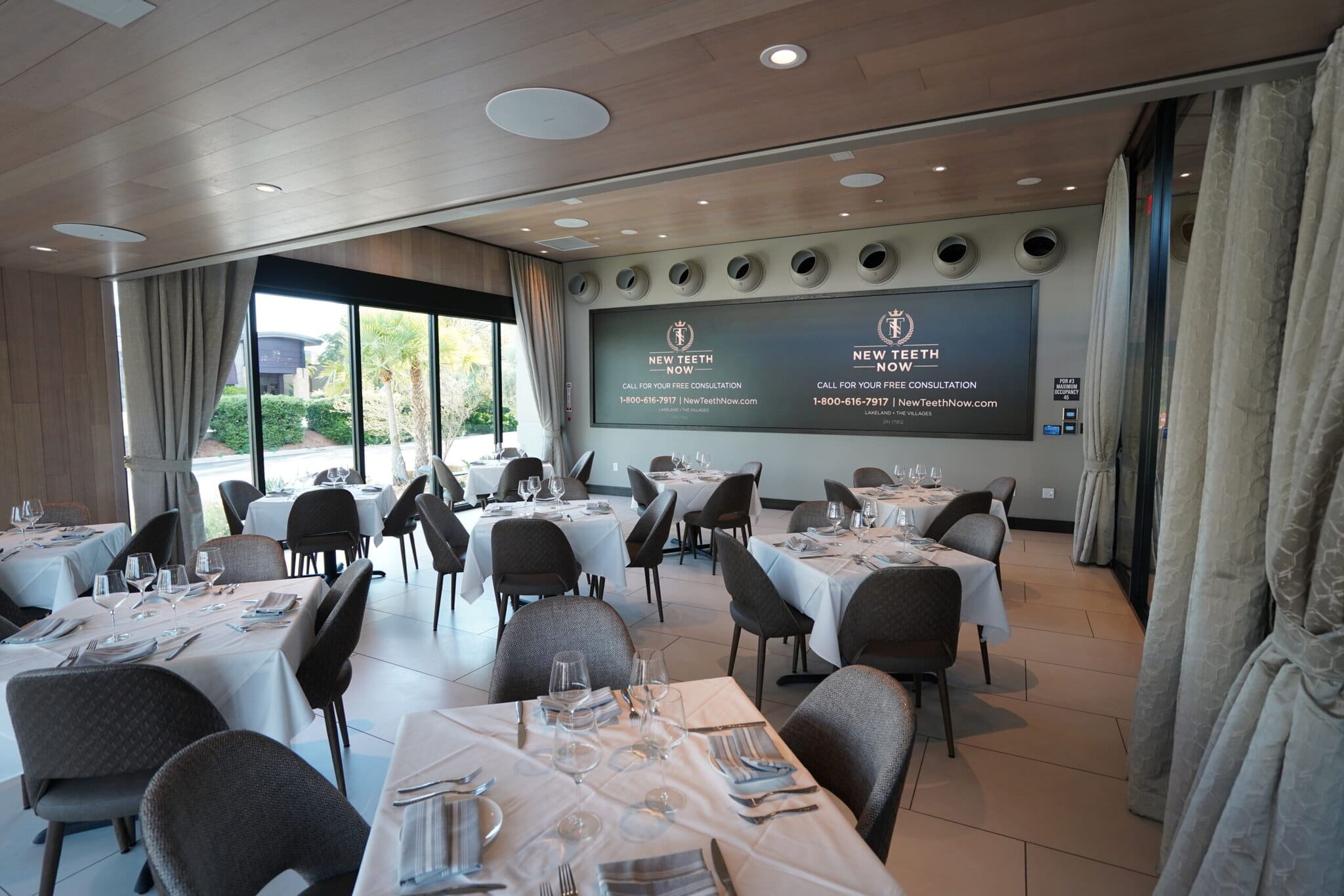 Elegant restaurant with tables set and large window.