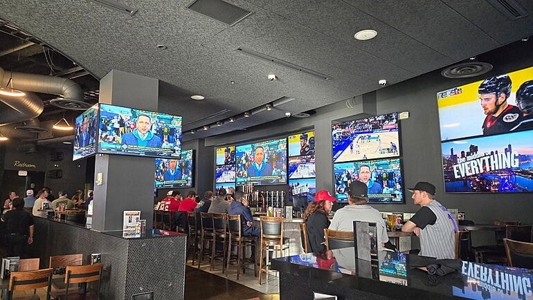 Sports bar with multiple TV screens and patrons.