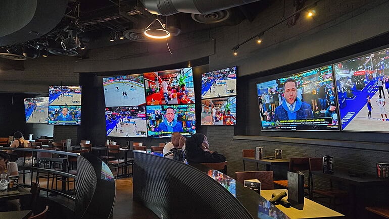 Sports bar interior with multiple TVs showing events.