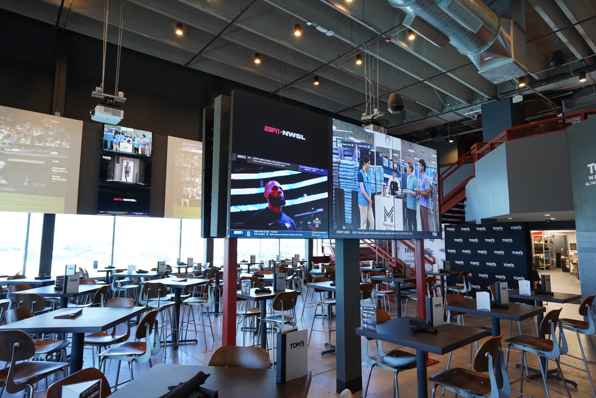 Sports bar with TV screens and dining tables.