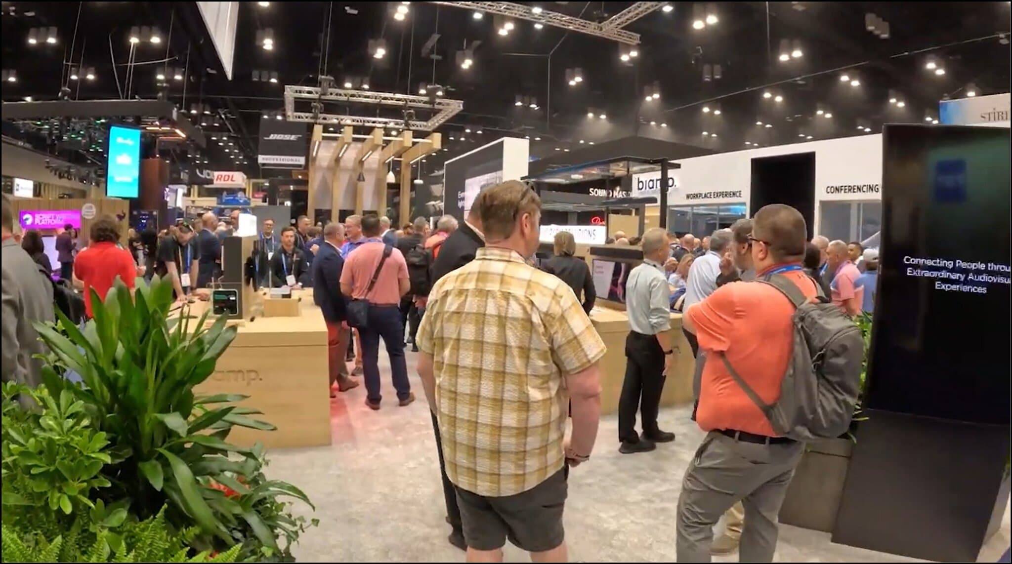 Crowded convention hall with various technology booths.