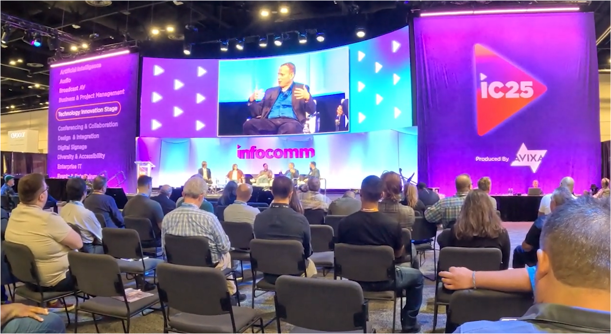 Audience attending technology innovation stage at conference.