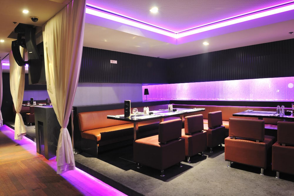 Modern restaurant interior with purple lighting.