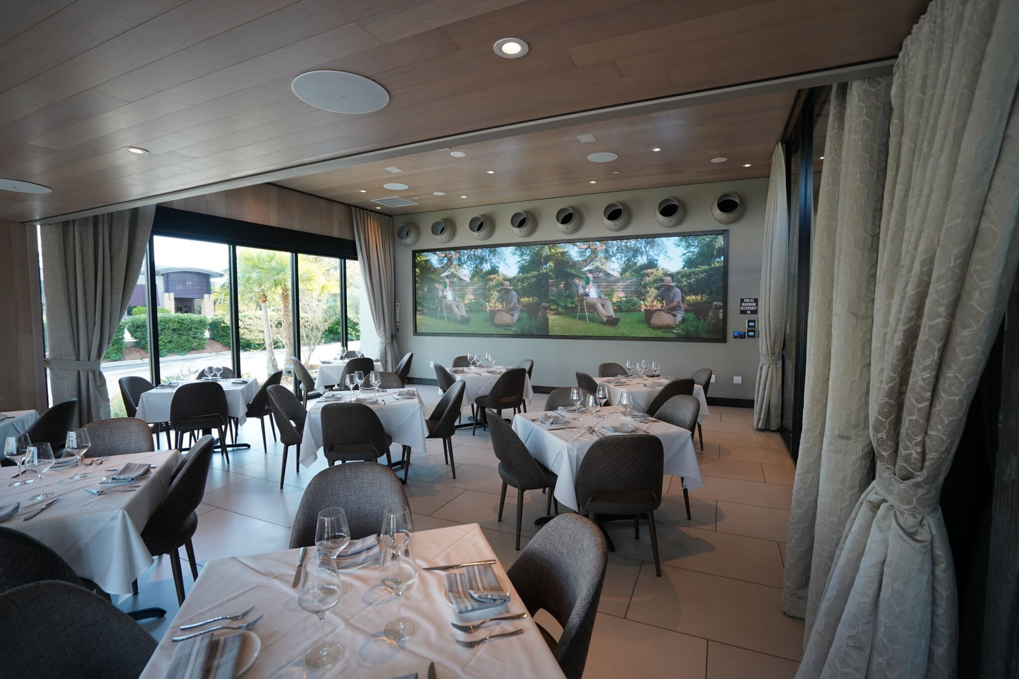 Elegant restaurant interior with large windows and tables.