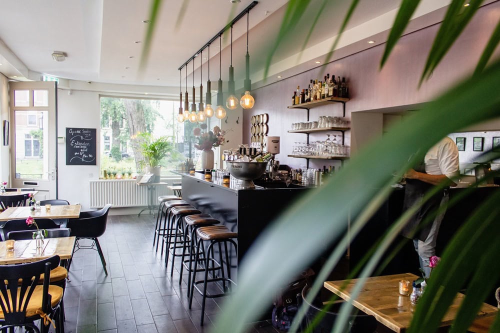 Modern cafe interior with bar and seating area.