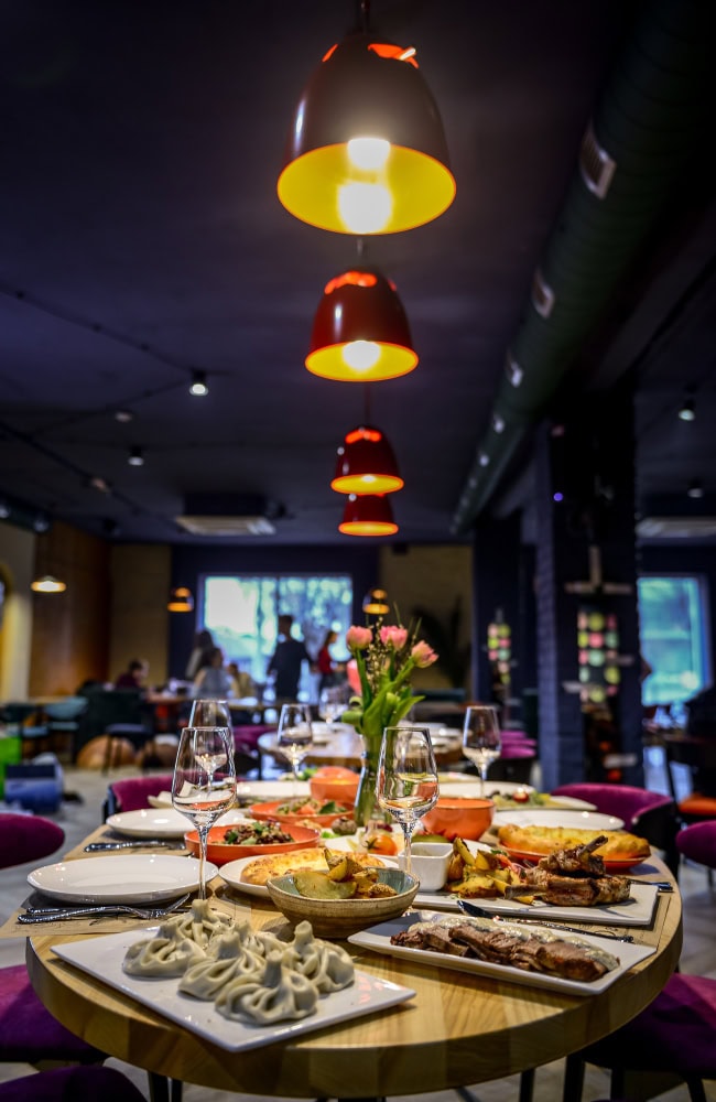 Restaurant table with assorted dishes and wine glasses.