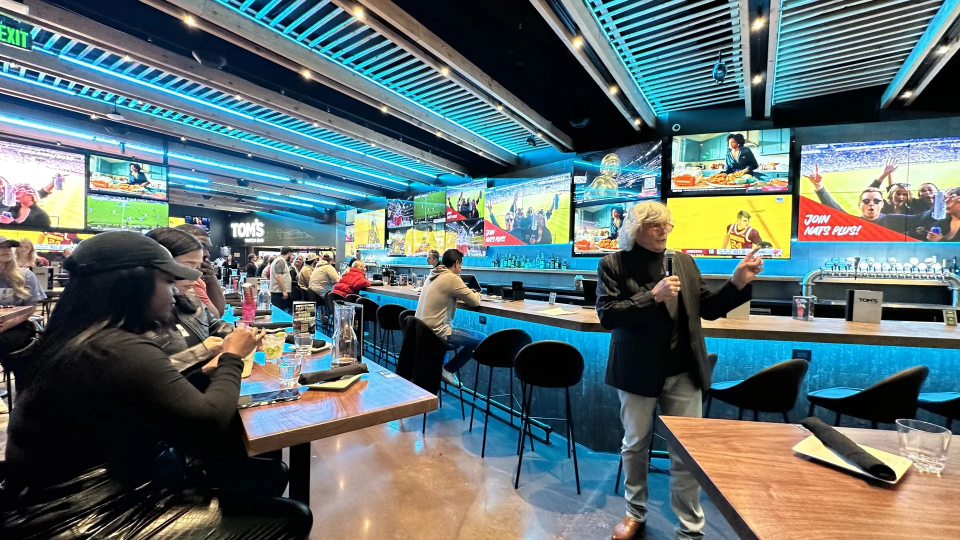People enjoying sports and drinks at a bar.