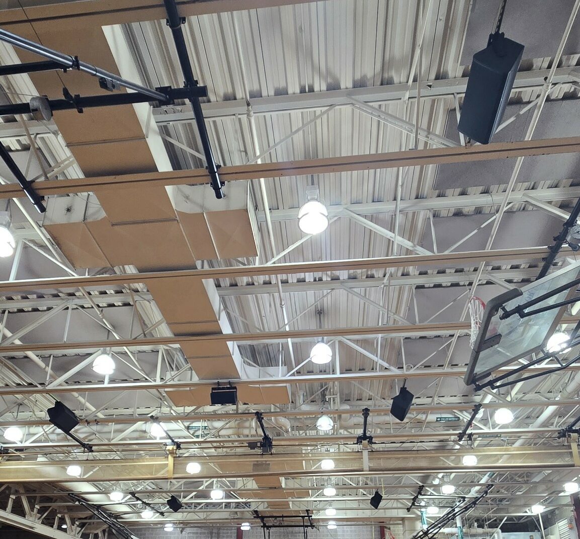 Empty indoor basketball court with scoreboard.