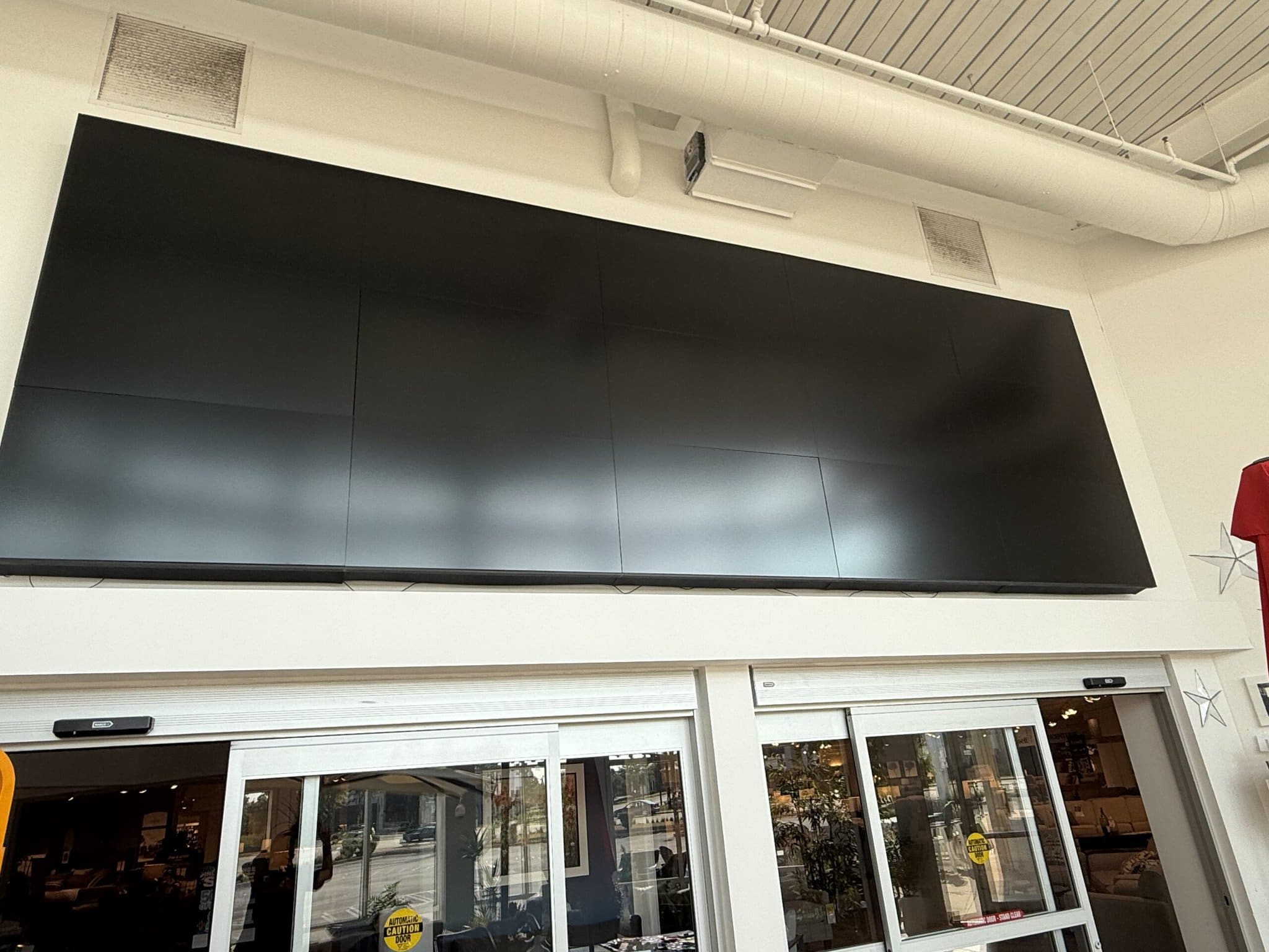 Large blank screen above store entrance.