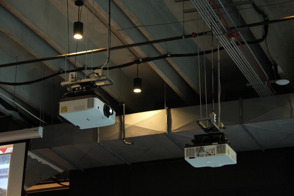 Ceiling projectors in an industrial-style room.