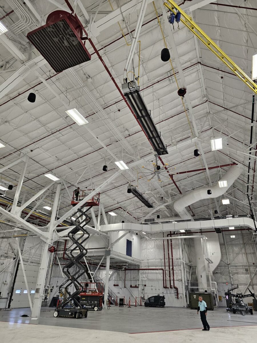 Scissor lift inside a large industrial warehouse space.