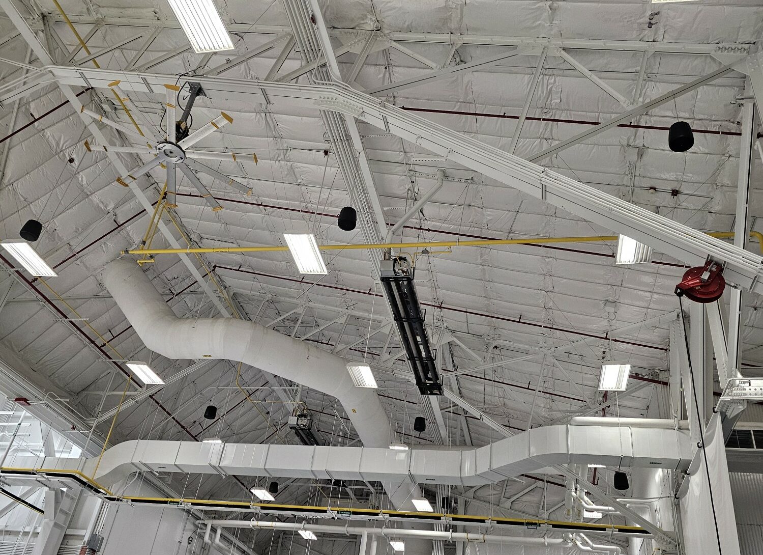 Large industrial warehouse ceiling with ventilation system.