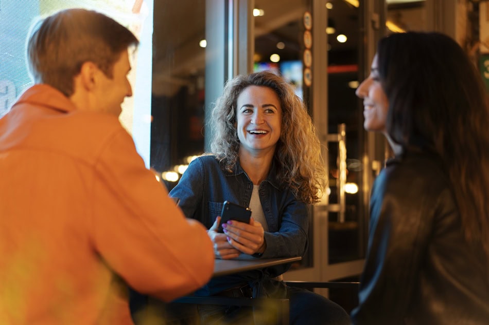 Friends smiling and chatting at a cafe