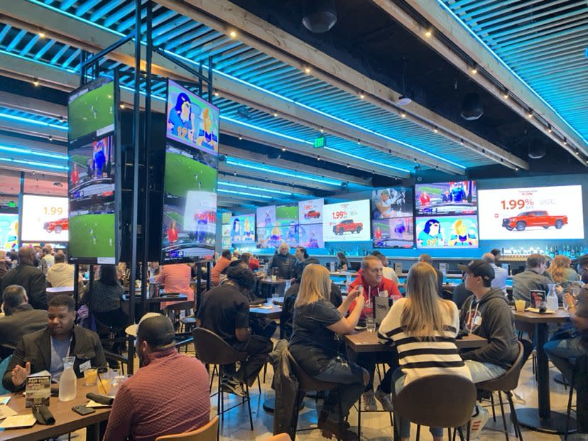 People dining in a sports bar with multiple screens.