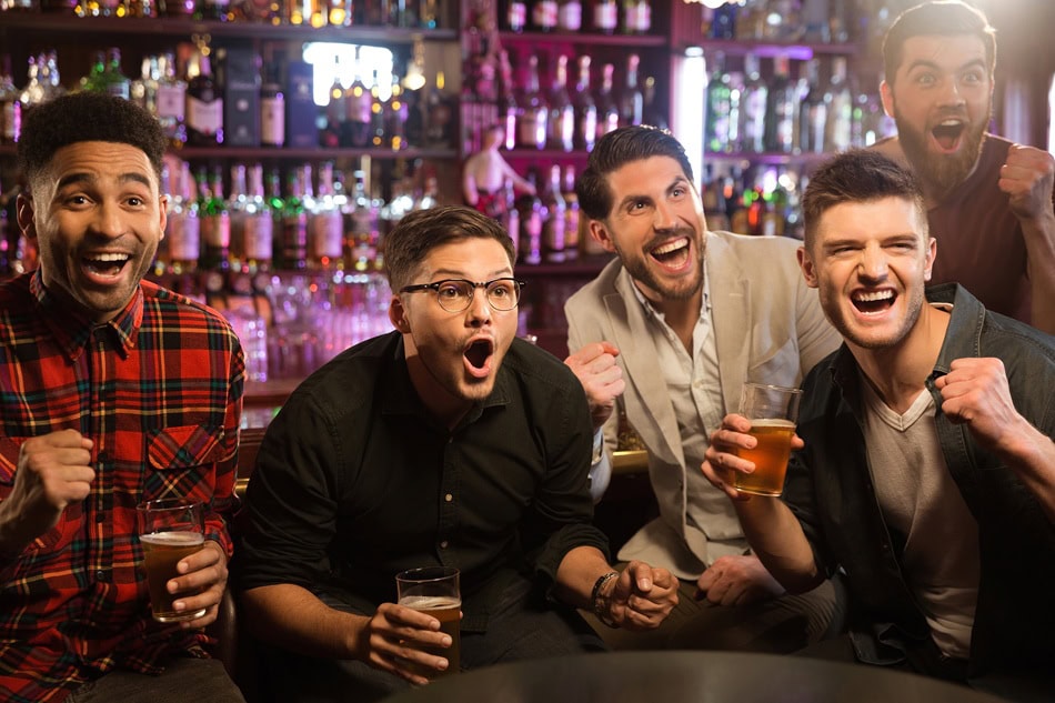 Group of friends cheering at a bar.