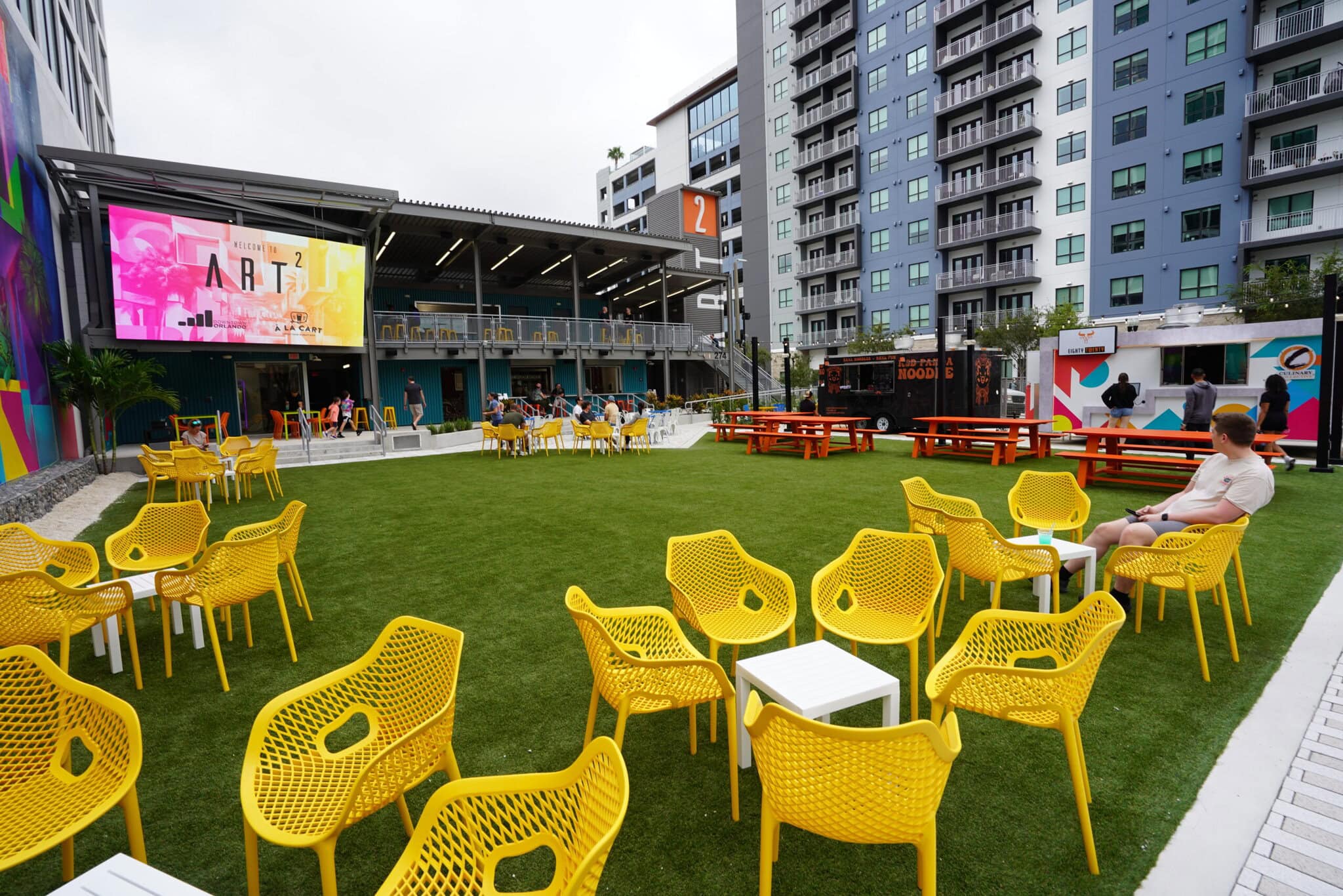 art 2 led video wall - Outdoor seating with colorful chairs and food trucks