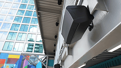 Security cameras on building exterior near windows.