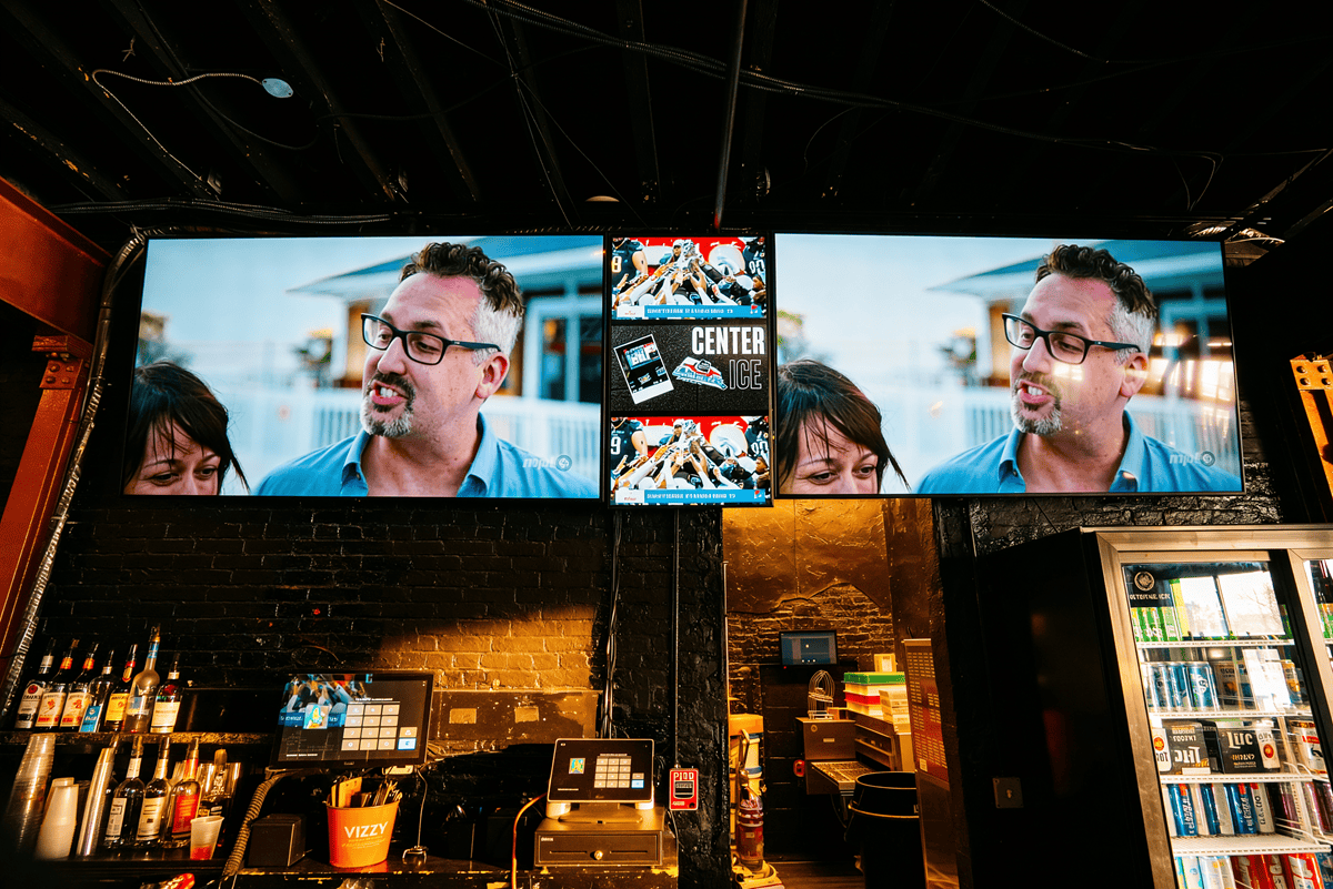 Bar area with multiple TV screens on wall.
