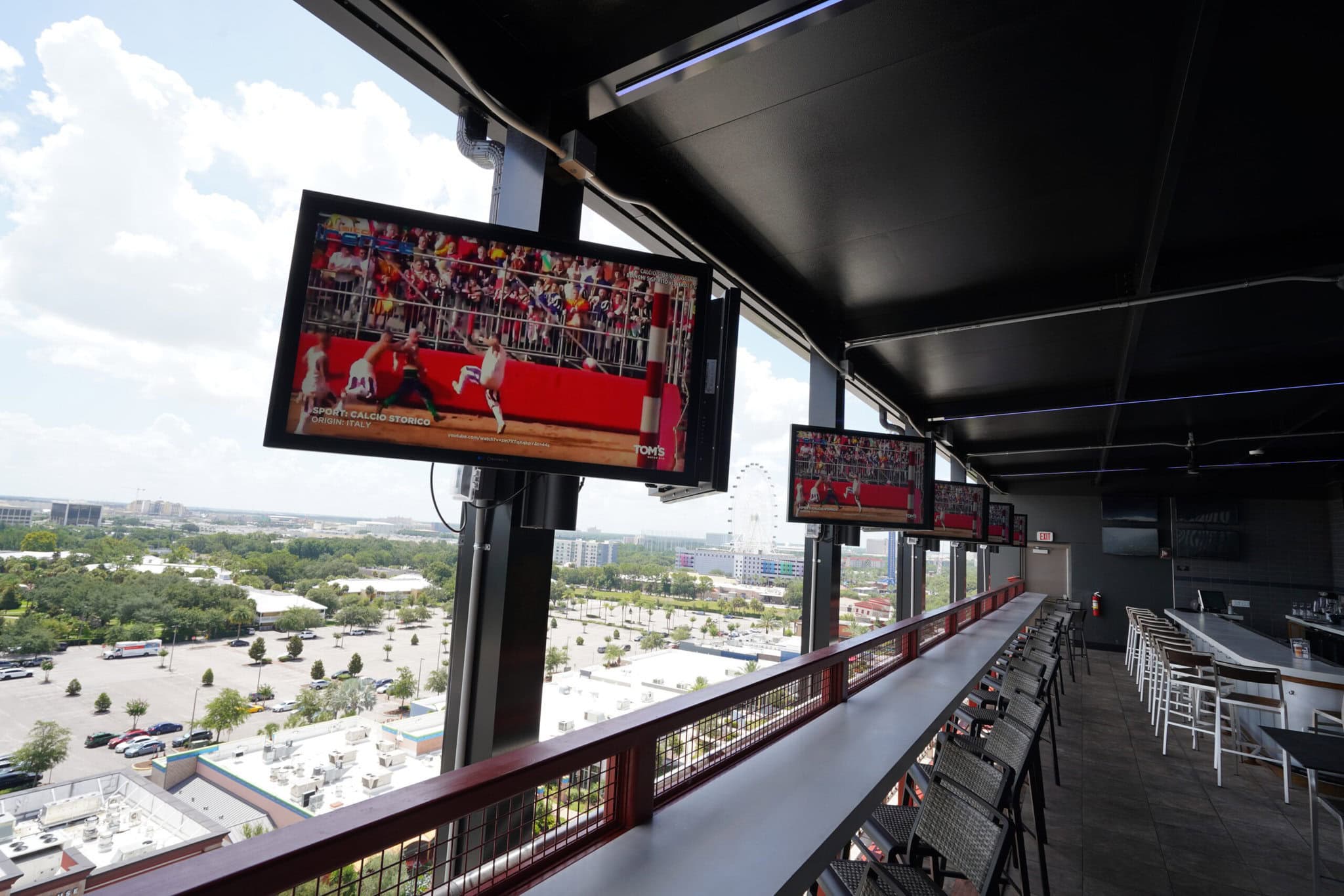 Sports bar with multiple TVs and city view.
