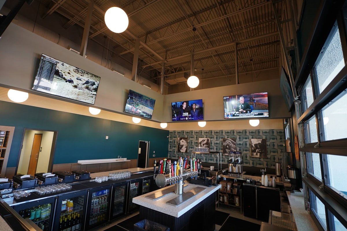 Bar interior with TVs and drinks.