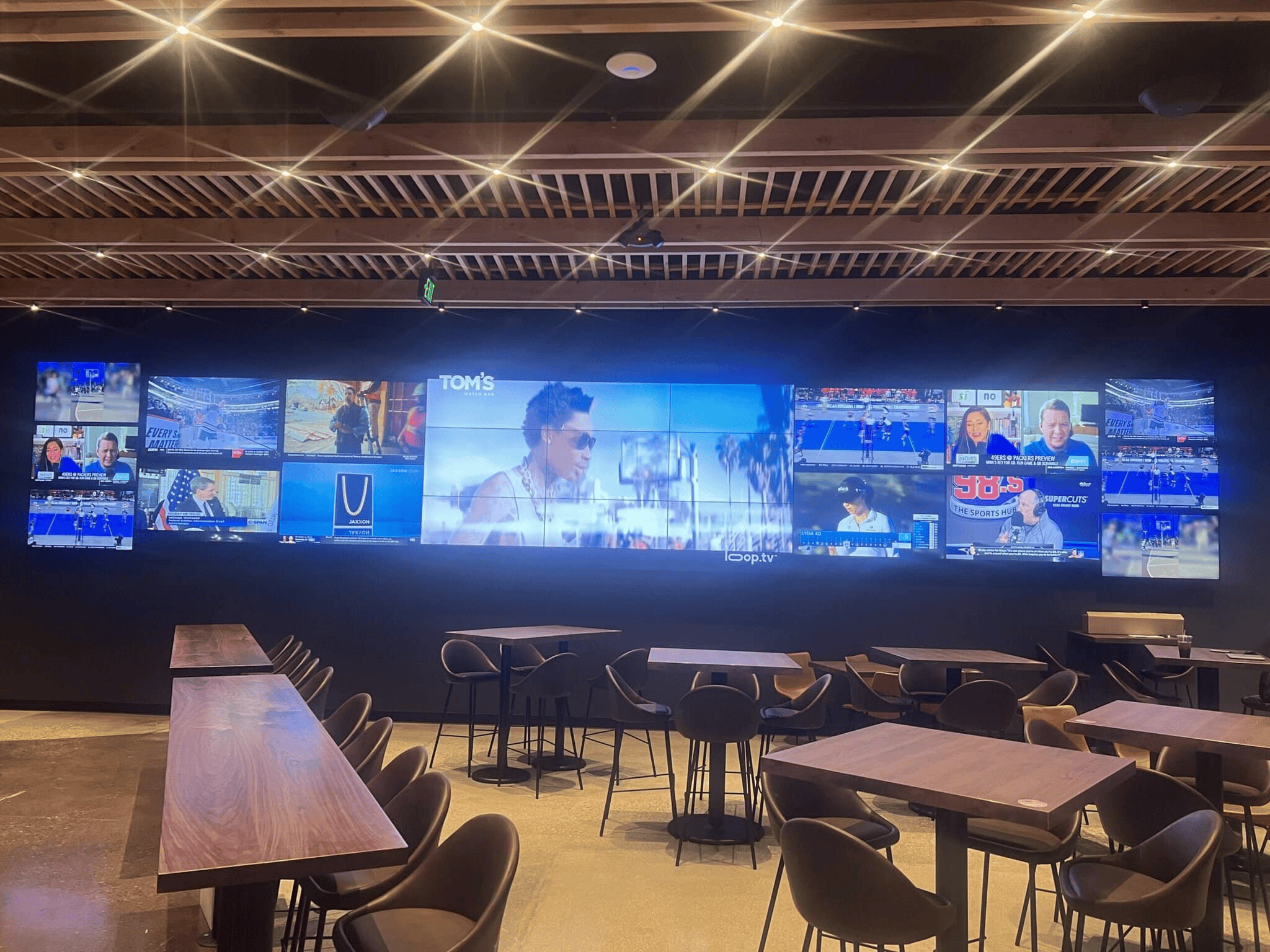 Sports bar with multiple TVs displaying various channels.