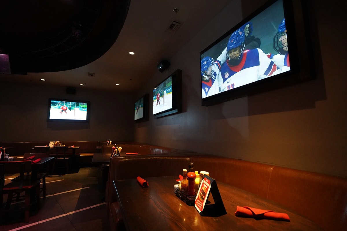 Sports bar with multiple TVs showing a hockey game.