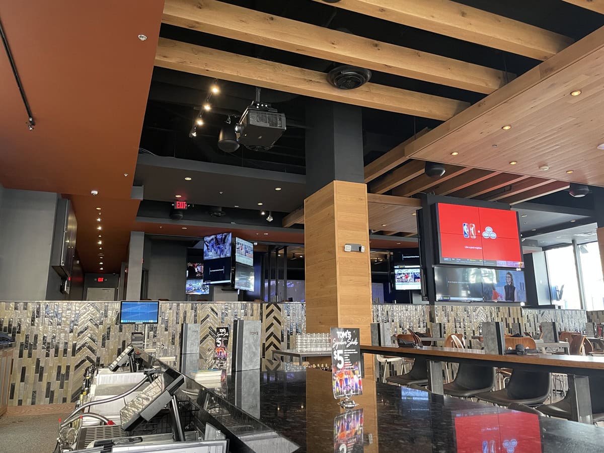Modern sports bar with multiple TV screens.