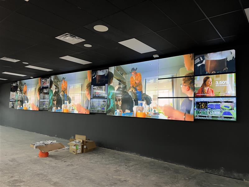 Large video wall with multiple screens in room.